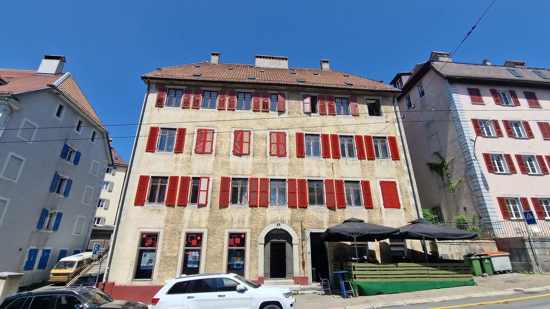 Façade with red shutters at rue Fritz-Courvoisier 11, La Chaux-de-Fonds
