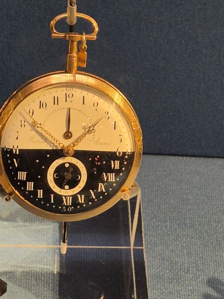 Gilt travel clock with a white enamel dial and a black day-and-night dial