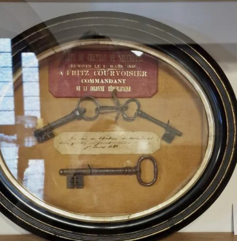 Keys of the Château de Neuchâtel in a glazed oval frame, with the red label recording their surrender to Fritz Courvoisier on 1 March 1848